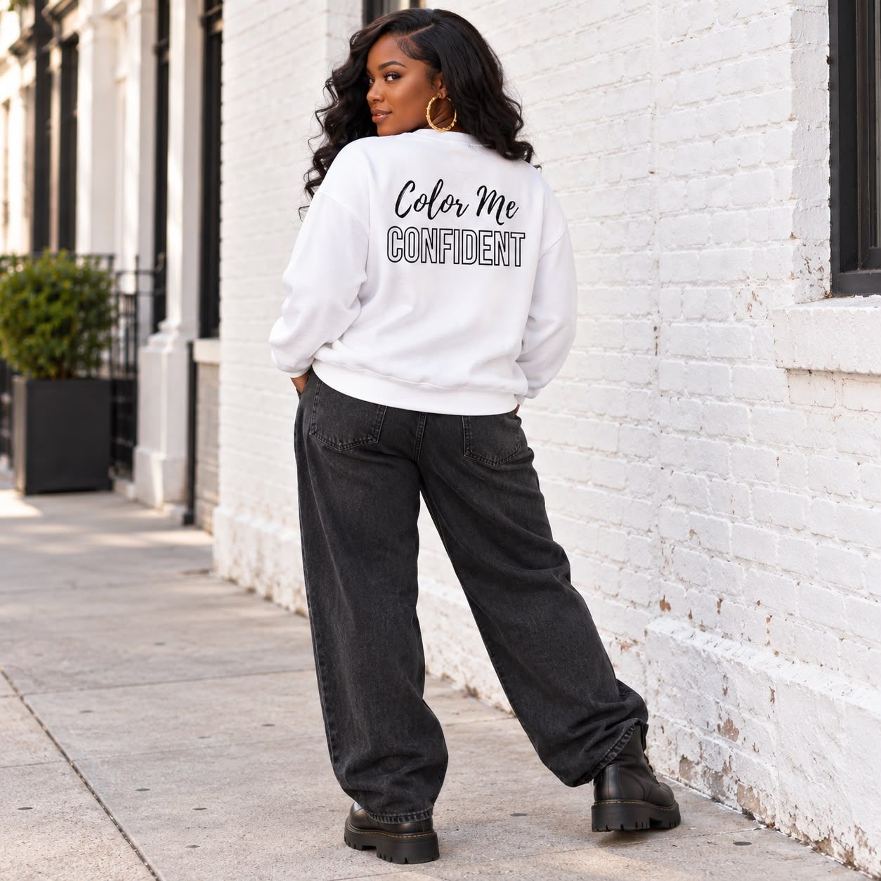 Woman in the white Color Me Confident crewneck, back view