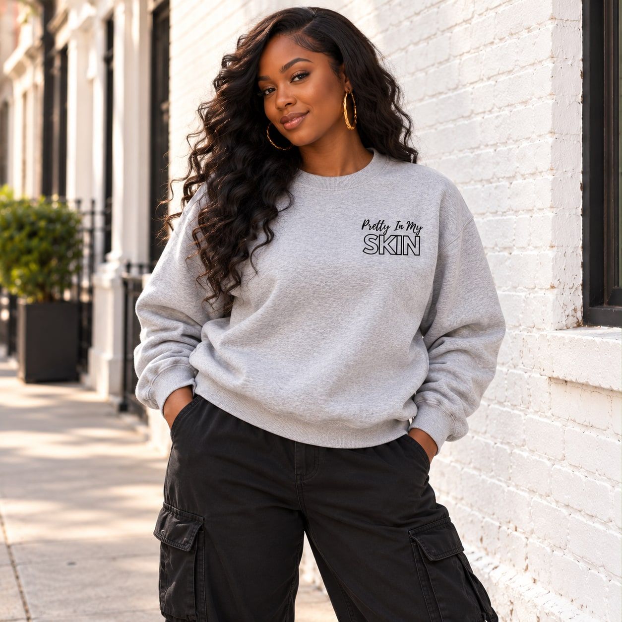 Woman in the ash grey crewneck showing the Pretty In My Skin chest print