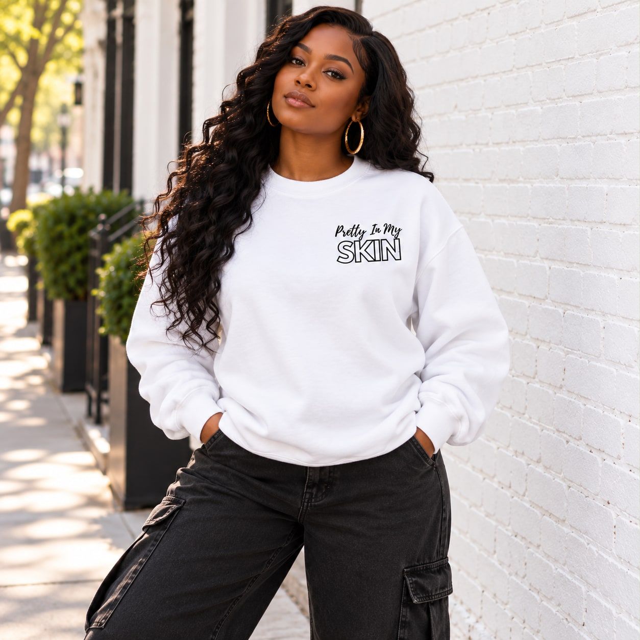 Woman in the white crewneck showing the Pretty In My Skin chest print